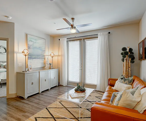 Modern apartment complex featuring a luxurious swimming pool, multiple hot tubs, and vibrant outdoor seating areas surrounded by lush landscaping.