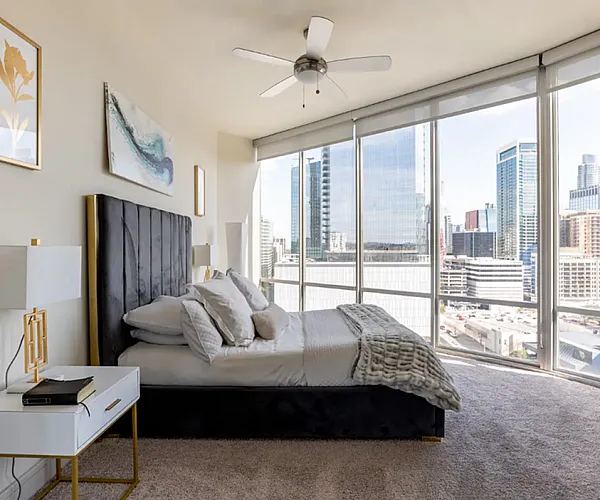 Luxurious rooftop pool area with stylish sun loungers and panoramic city views, perfect for relaxing and enjoying the vibrant skyline.