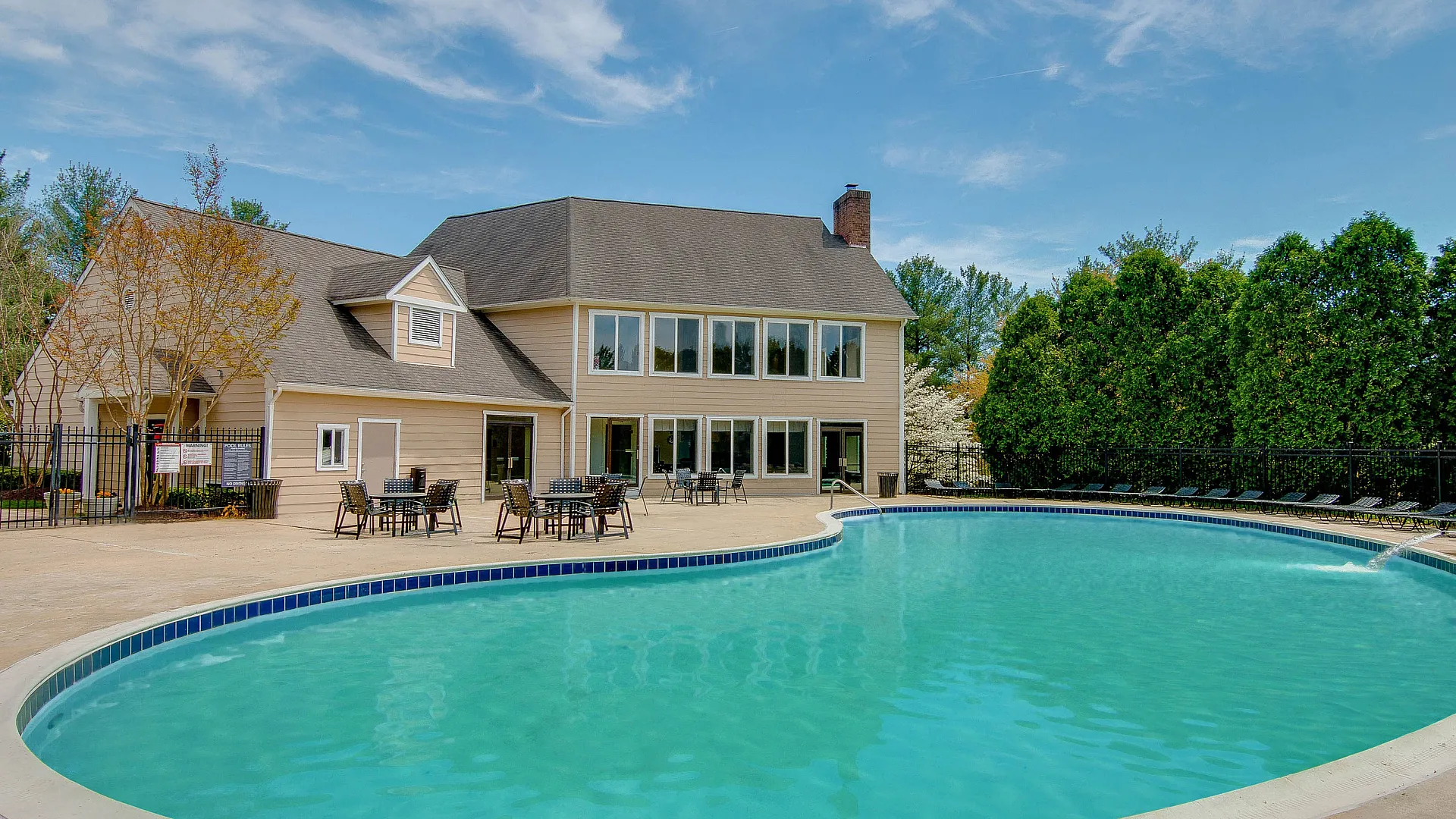 Charming residential area featuring a luxurious swimming pool and inviting patio seating, ideal for relaxation and social gatherings.