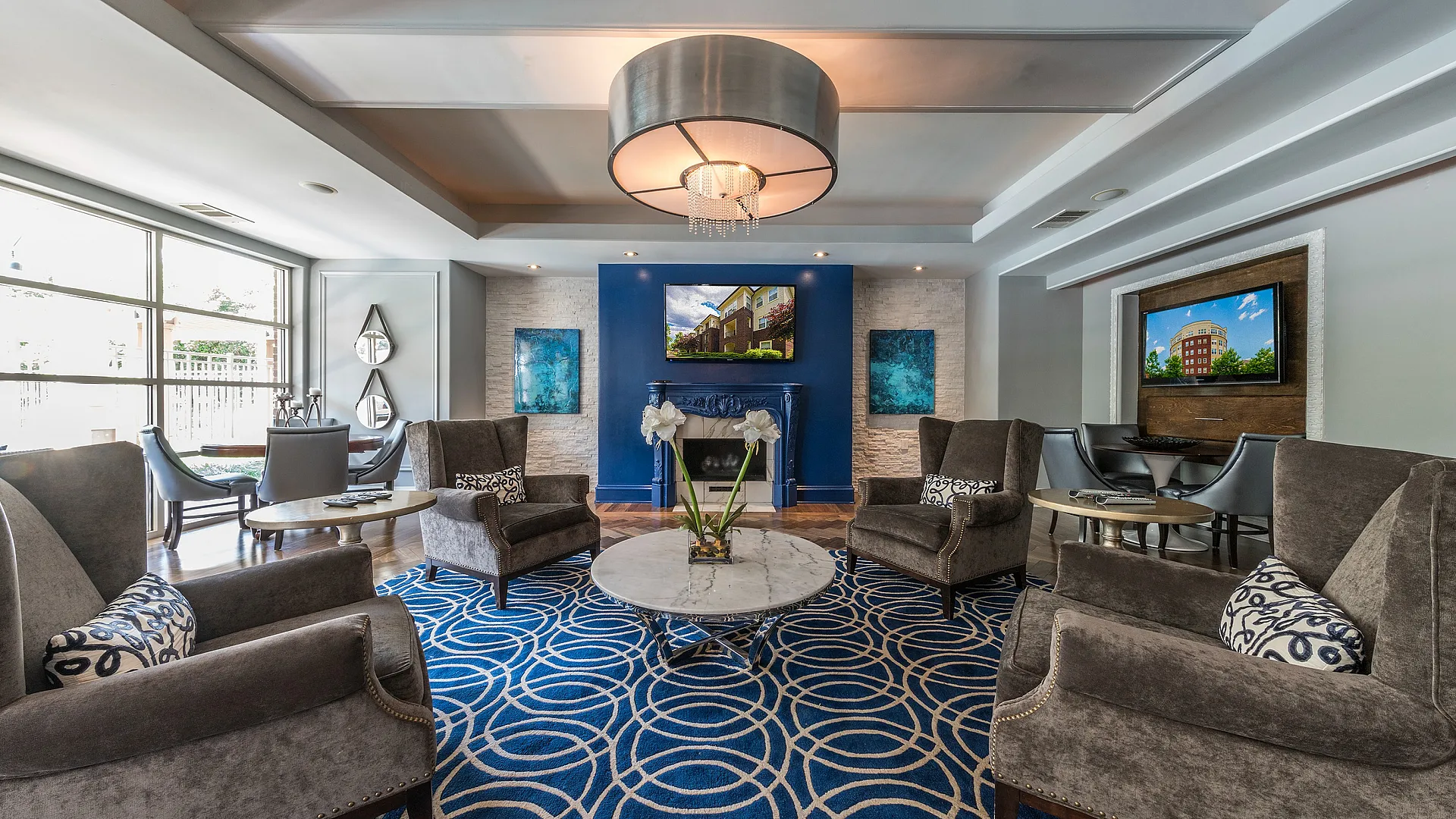 Luxurious and inviting lounge area featuring elegant armchairs, stylish decor, and a vibrant blue patterned rug.