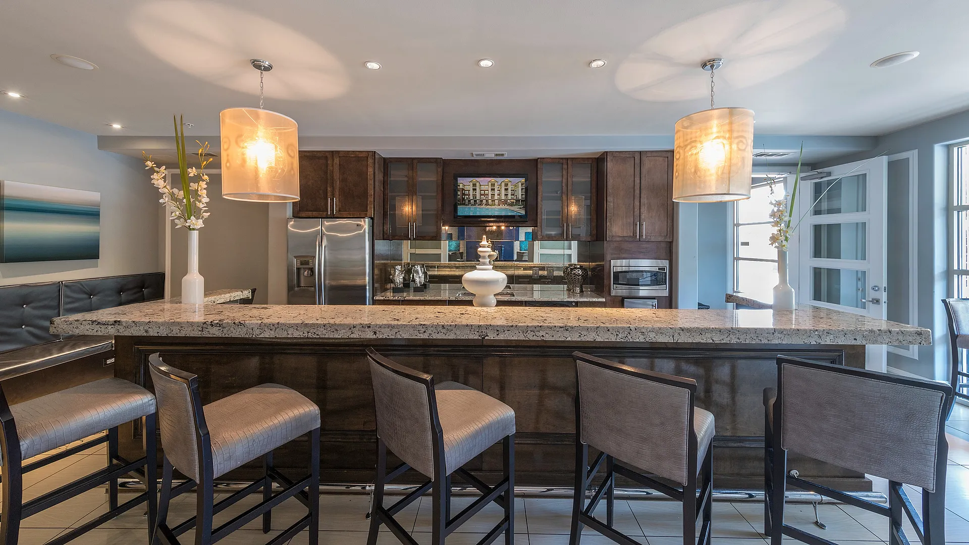 Elegant kitchen featuring a spacious marble countertop with stylish bar seating and modern pendant lighting.
