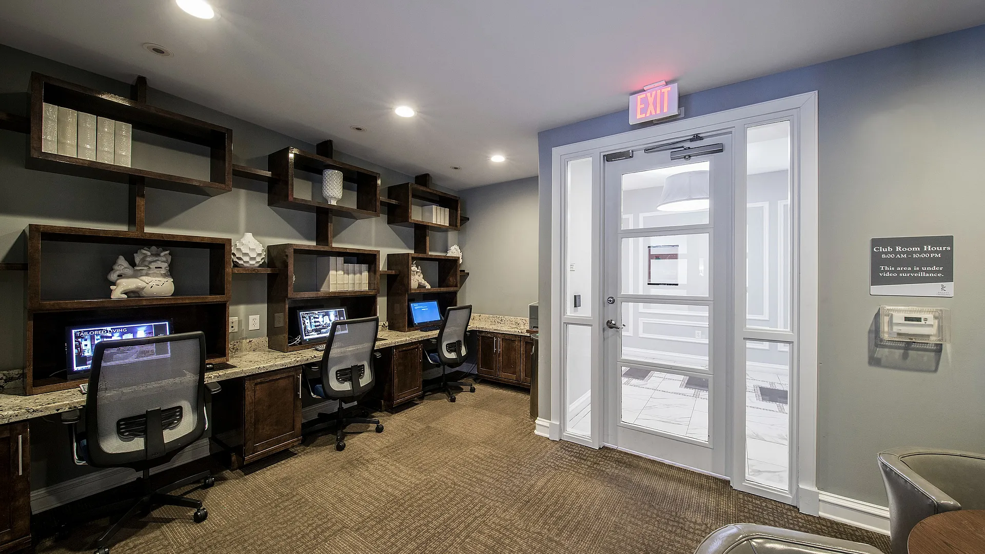 Elegant business center with modern workstations, stylish shelving, and ambient lighting, perfect for productivity.