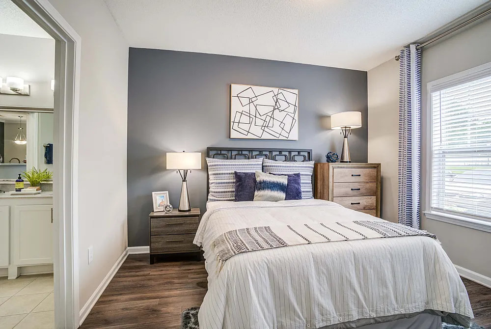 Cozy bedroom featuring a stylish design with modern decor and natural light through elegant window blinds.