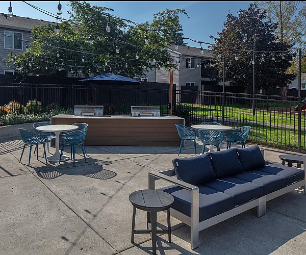 Charming outdoor patio area featuring cozy seating, stylish dining tables, and beautiful string lights, perfect for entertaining.