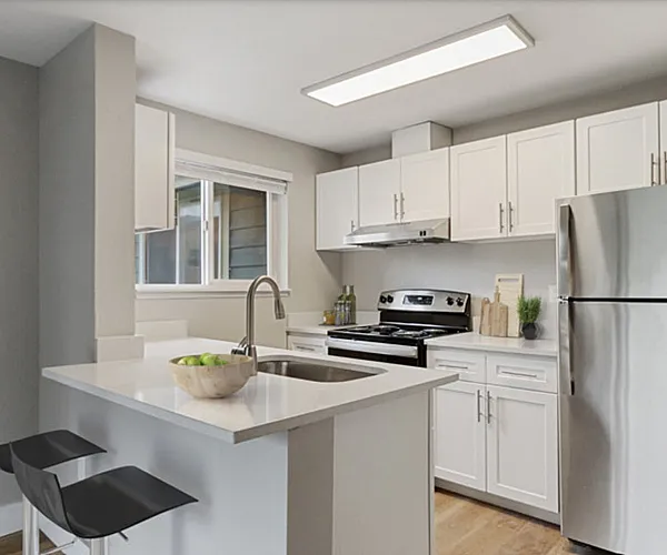 Modern kitchen with sleek white cabinets, stainless steel appliances, and a chic breakfast bar with black stools.