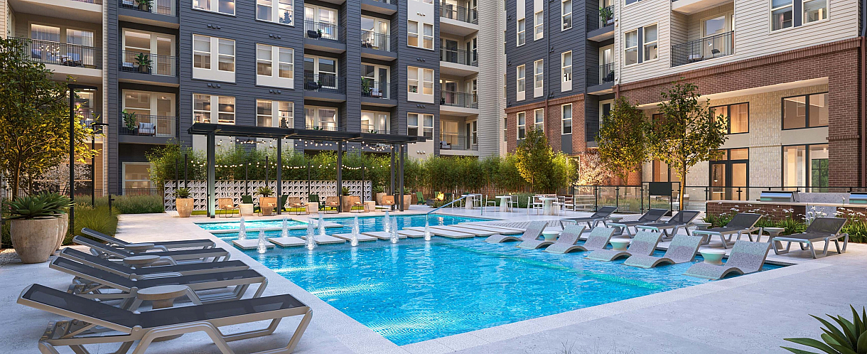 Modern apartment complex featuring a luxurious pool area surrounded by stylish loungers and lush landscaping, set against a backdrop of sleek multi-story buildings with private balconies.