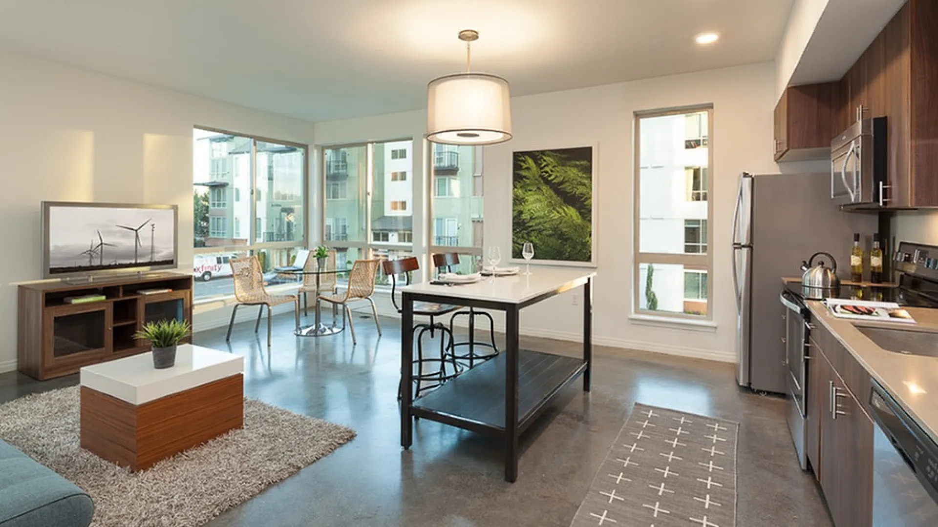 Modern open-concept living area with elegant kitchen, stylish dining space, and cozy seating in a bright, inviting apartment.