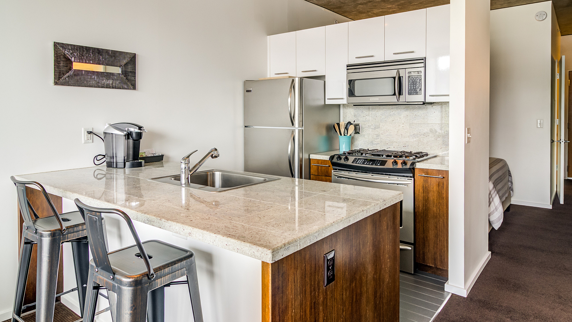 Modern kitchen layout showcasing sleek stainless steel appliances, a chic island with bar seating, and elegant cabinetry.