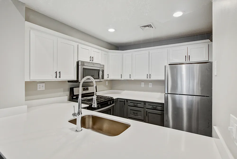 Modern kitchen with sleek stainless steel appliances, elegant white cabinetry, and a stylish faucet.
