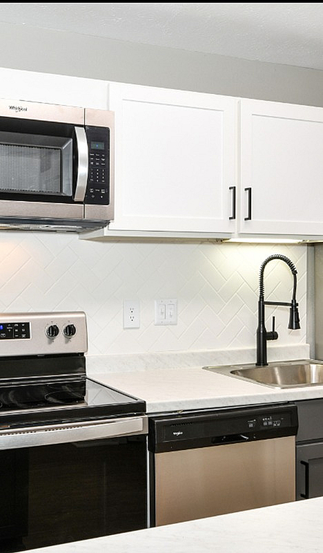 Modern kitchen with sleek stainless steel appliances, elegant cabinetry, and a stylish backsplash creating a contemporary vibe.