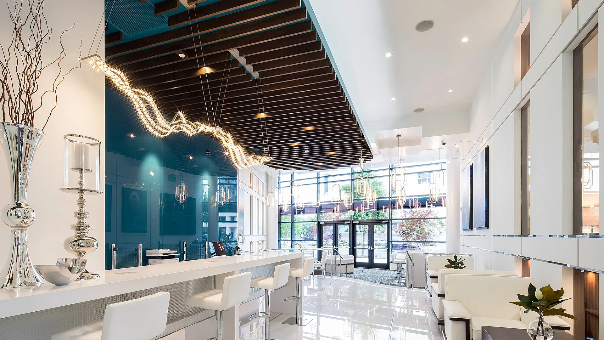 Luxurious modern lounge area with sleek bar seating, contemporary lighting, and stylish decor, offering a spacious and inviting atmosphere.