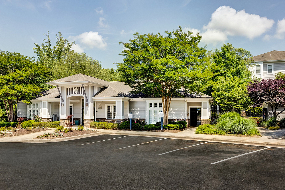 Charming residential building with a welcoming entrance, manicured landscaping, and ample parking space. Ideal for modern living.