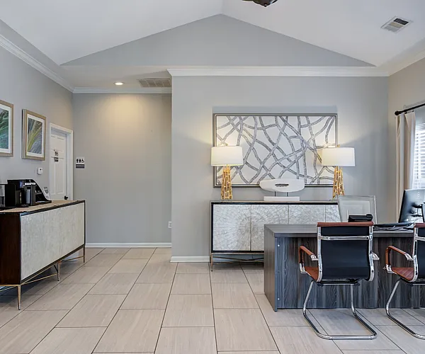 Elegant apartment office area with modern decor, sleek desk, and stylish seating, highlighted by natural lighting and contemporary artwork.