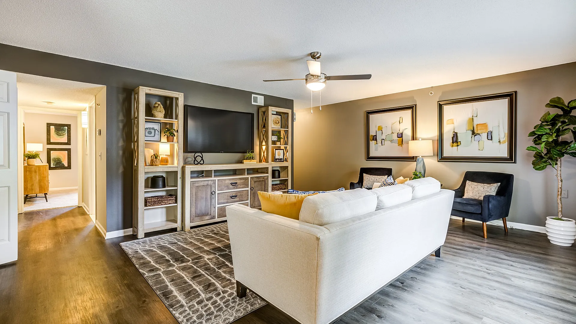 Modern and inviting living room with comfortable seating, elegant wall art, and stylish entertainment center, perfect for relaxing or entertaining.