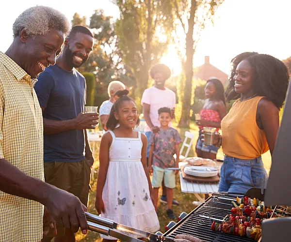 Joyful backyard barbecue with family and friends enjoying a sunny day.