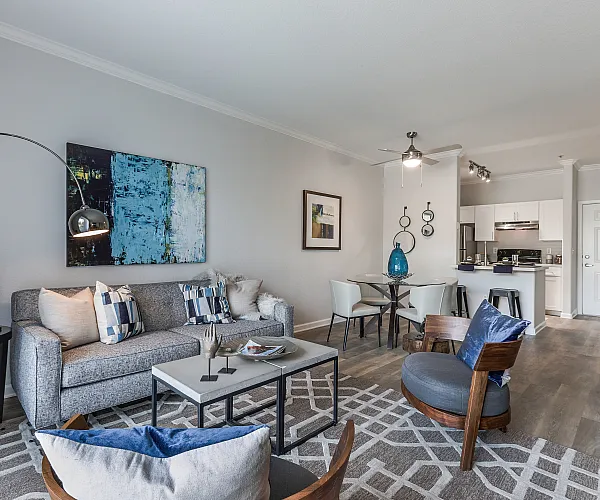 Contemporary open-concept living area with sleek decor, featuring a cozy seating arrangement, modern dining table, and stylish kitchen with bar seating.