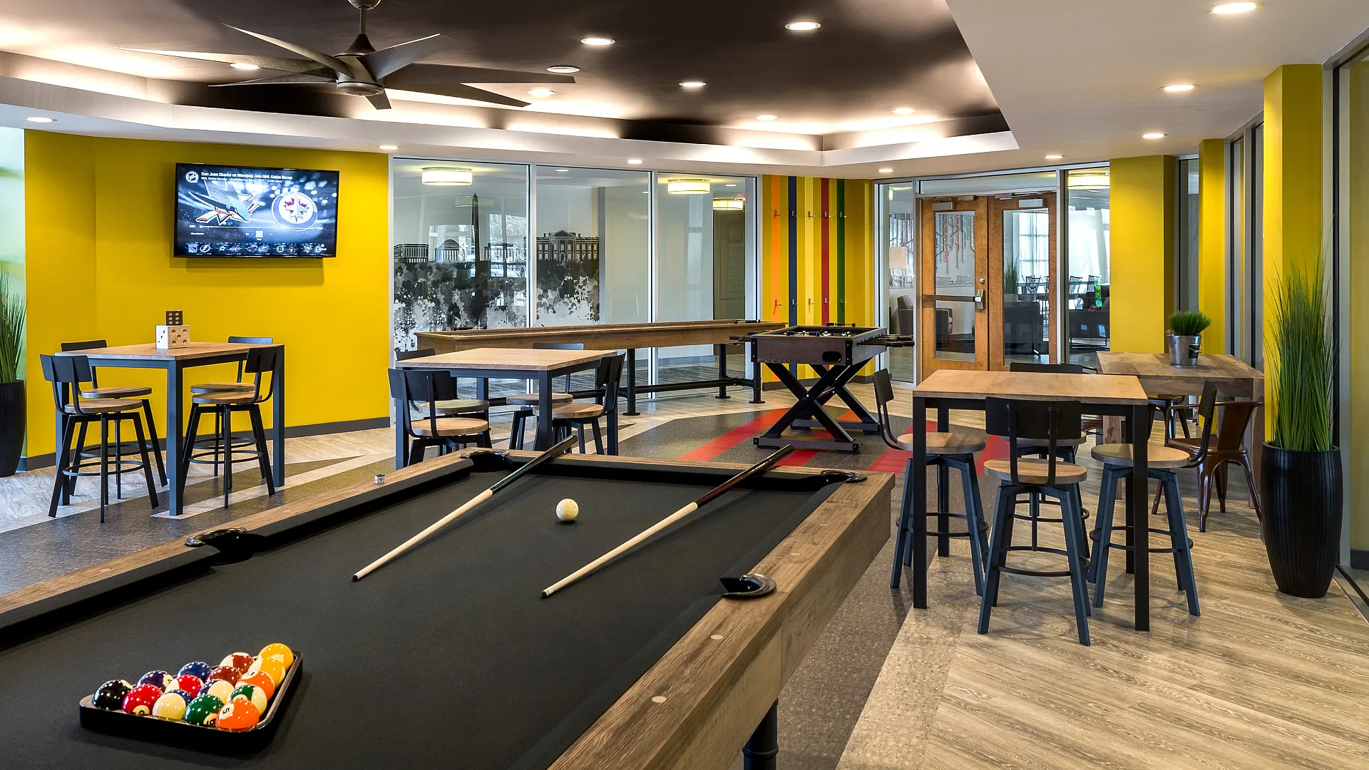 Vibrant entertainment room with a sleek pool table, modern seating, and colorful accents, perfect for social gatherings.