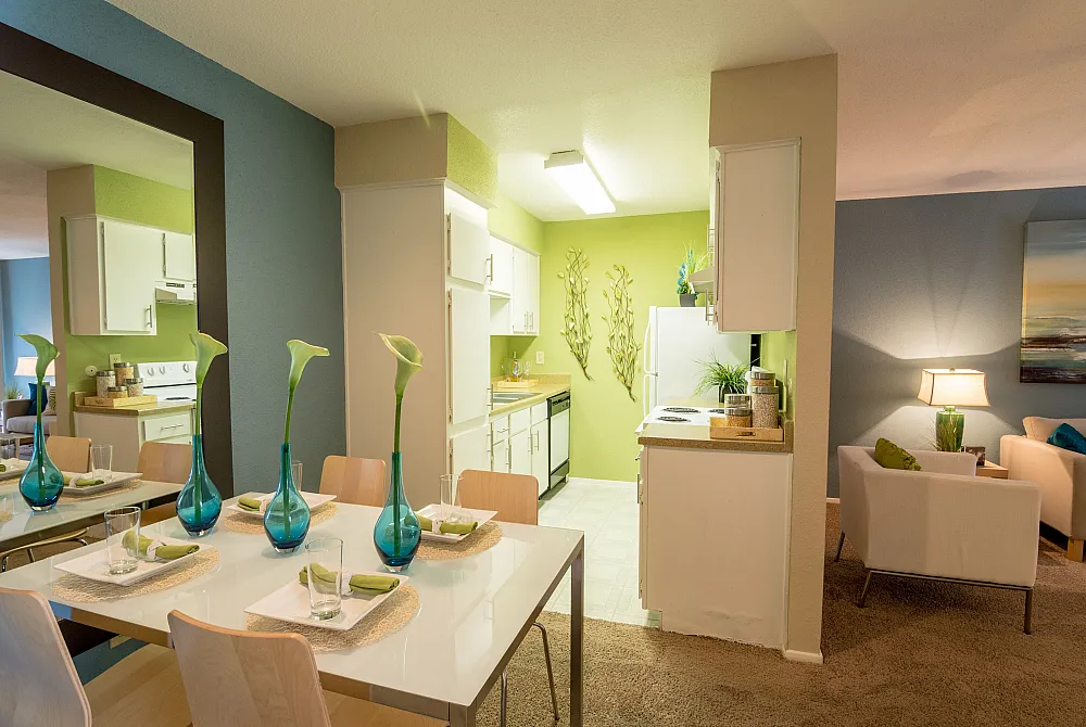 Elegant apartment interior showcasing a stylish dining area with modern decor, adjacent to a vibrant kitchen and cozy living space. Perfect for contemporary living.