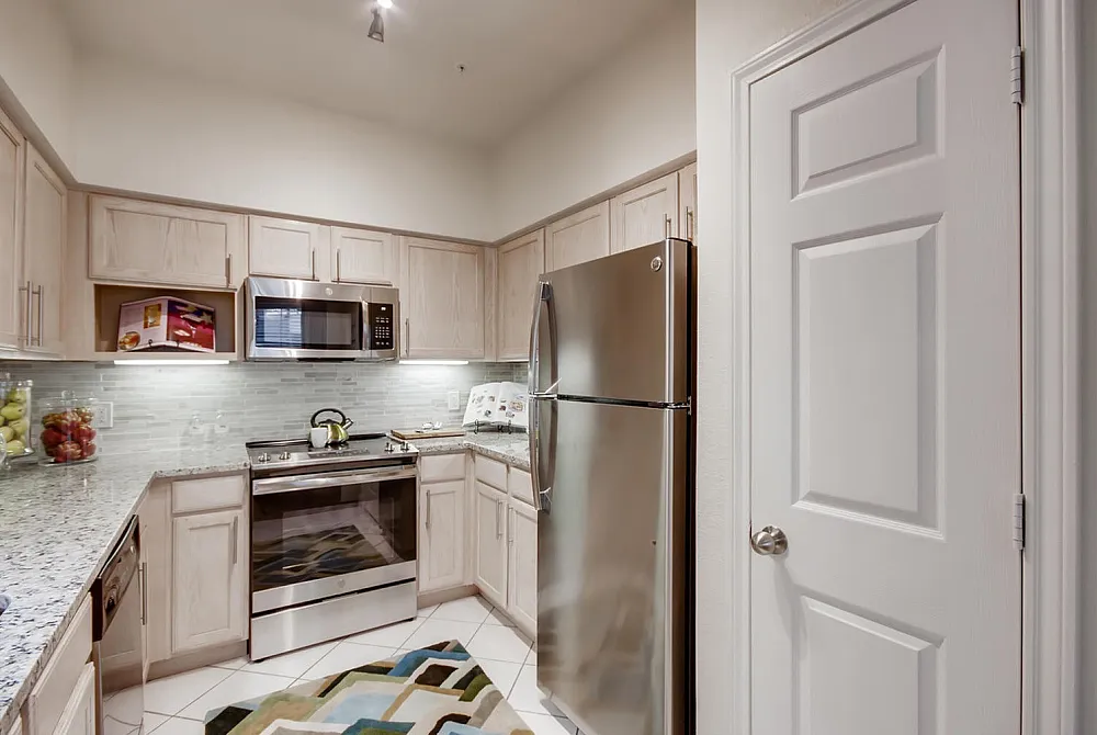 Modern kitchen design featuring sleek stainless steel appliances, bright cabinetry, and elegant granite countertops.