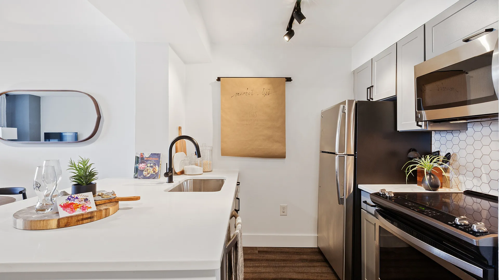 Modern kitchen with sleek stainless steel appliances, elegant white countertops, and a stylish backsplash, offering a bright and inviting space.