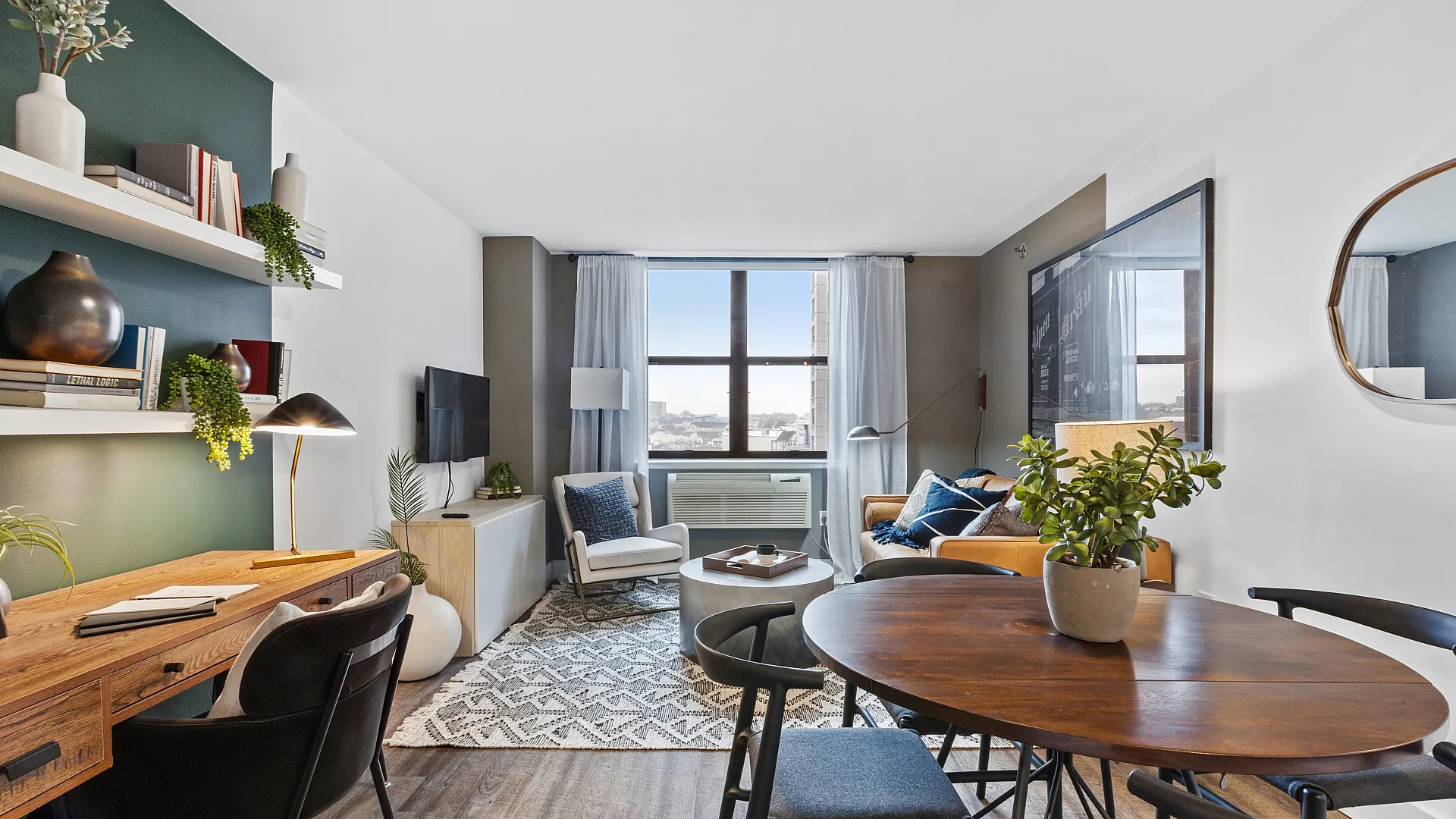 Modern living room with large window, stylish decor, cozy seating area, and a wooden dining table.
