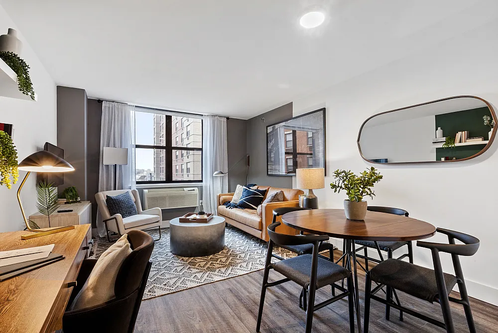 Chic urban apartment living room featuring a cozy seating area, stylish decor, and a large window overlooking city views. Includes a versatile workspace and a charming dining nook.