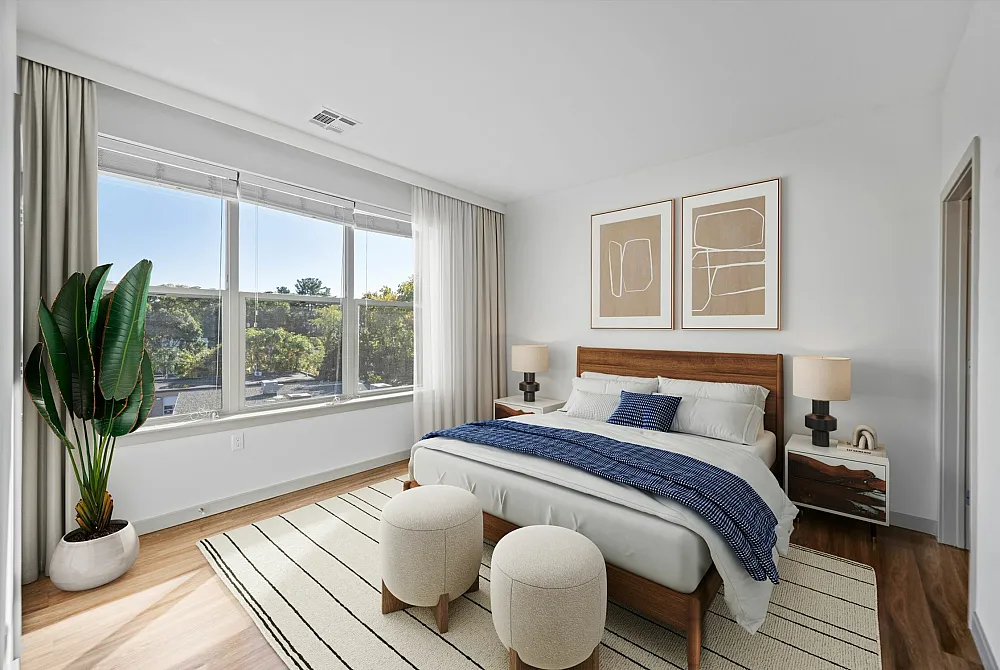 Bright and inviting bedroom with large windows, modern decor, and a cozy ambiance.