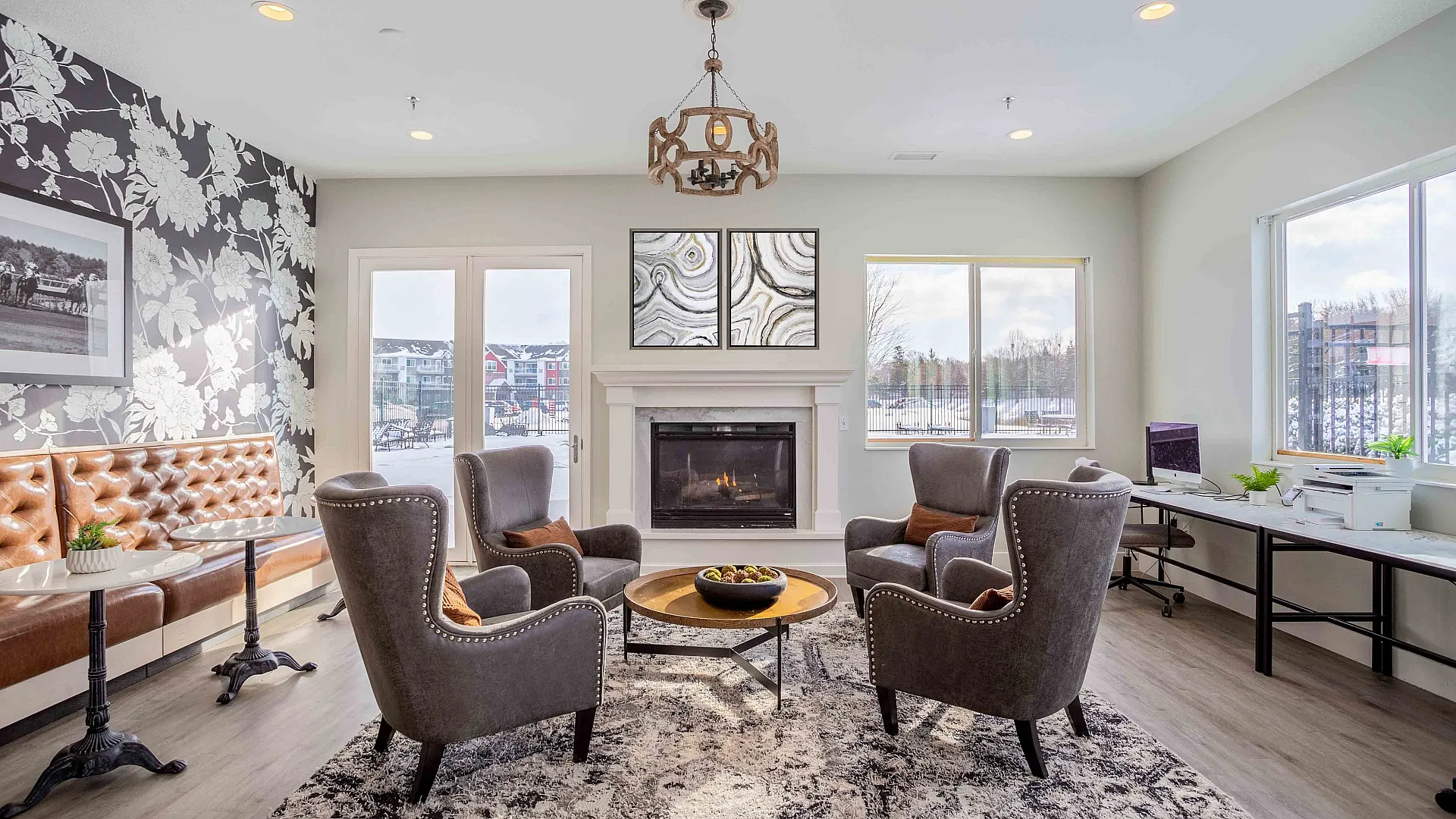 Elegant living room with modern decor, featuring cozy armchairs, a stylish fireplace, and large windows offering plenty of natural light.