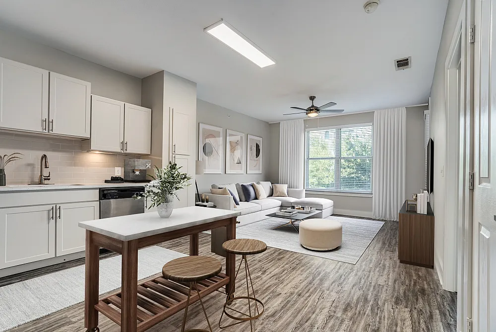 Chic open-plan living space with contemporary kitchen, cozy sectional sofa, and large windows inviting natural light.