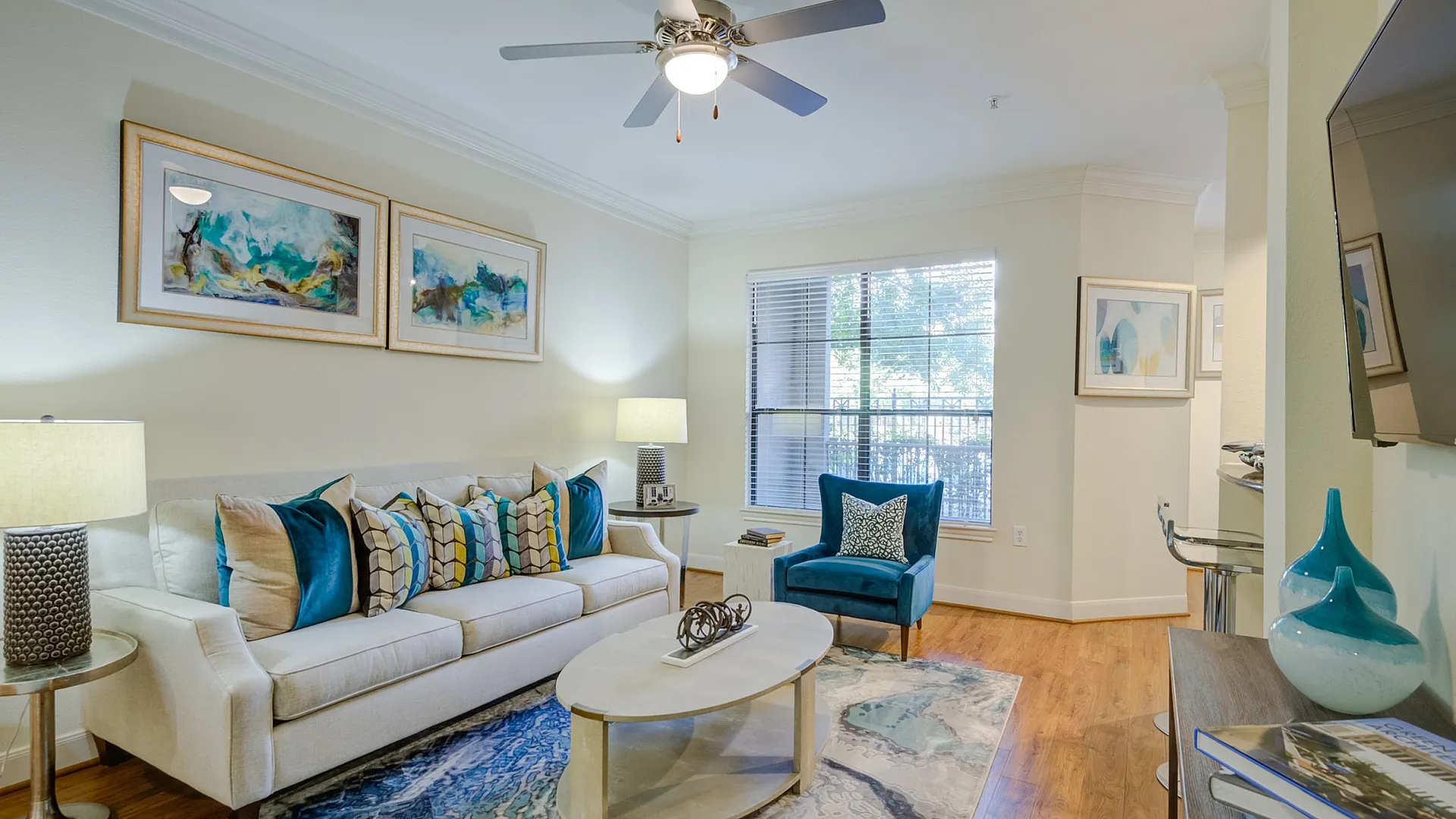 Elegant living room boasting a plush sofa with vibrant pillows, a contemporary coffee table, and chic artwork, illuminated by natural light and stylish lamps.