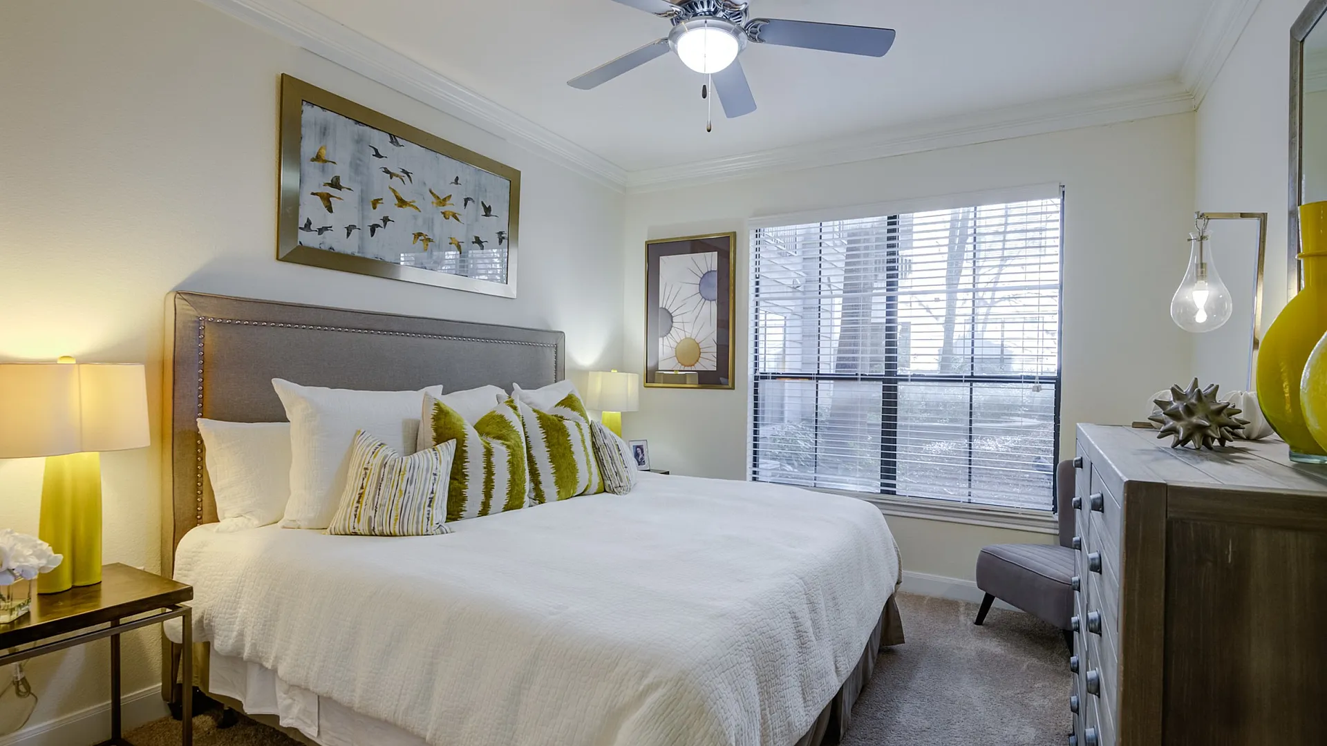 Inviting bedroom with elegant decor, featuring a comfortable bed, stylish artwork, and ample natural light.