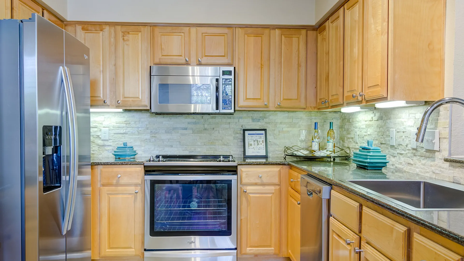 Chic modern kitchen with stainless steel appliances, sleek wooden cabinetry, and elegant stone backsplash.
