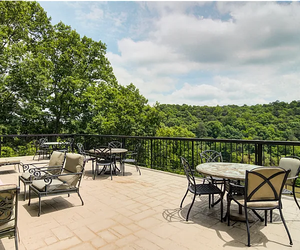 Luxurious outdoor terrace with elegant patio furniture and stunning panoramic views of lush greenery.