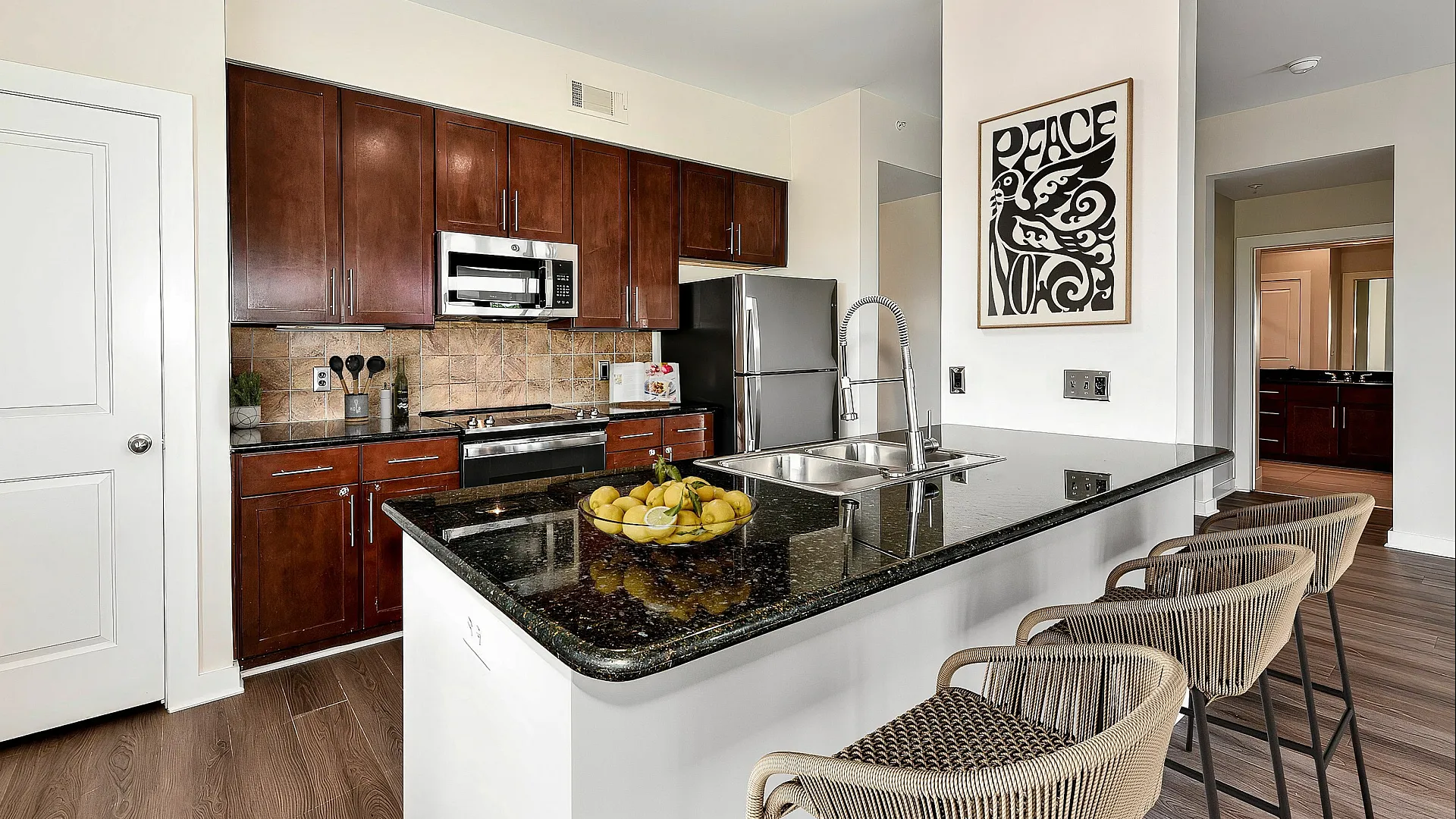 Modern kitchen with sleek wooden cabinets, stainless steel appliances, and a chic island with seating, perfect for entertaining.