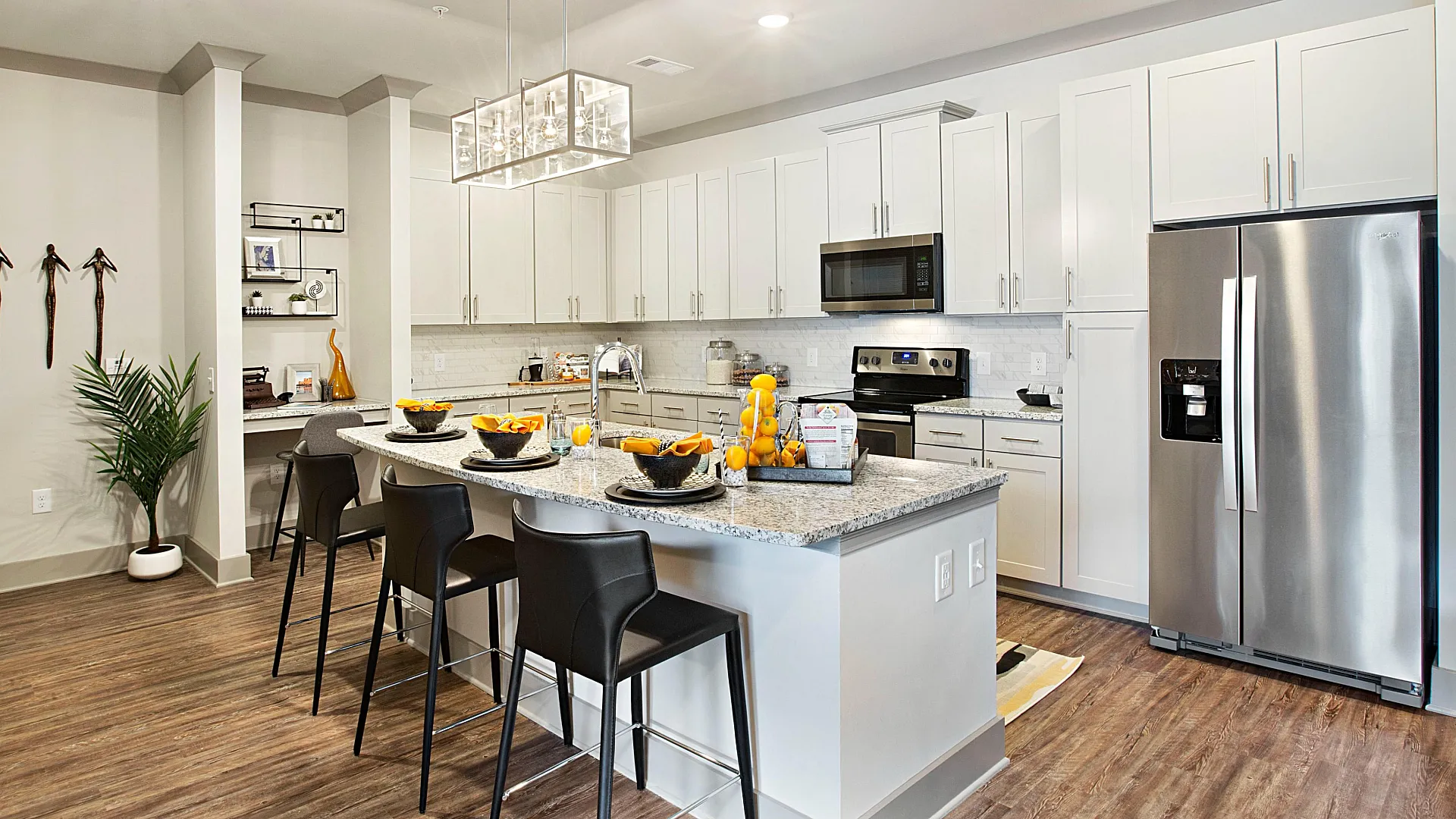 Modern kitchen with sleek white cabinetry, stainless steel appliances, and a stylish island with contemporary bar seating, creating a welcoming and functional space for cooking and entertaining.