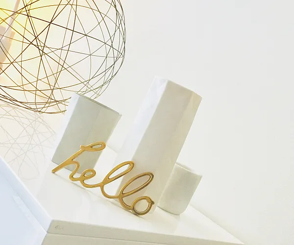 Contemporary decor with a warm welcome vibe, featuring white minimalist accents and a stylish wire orb lamp.