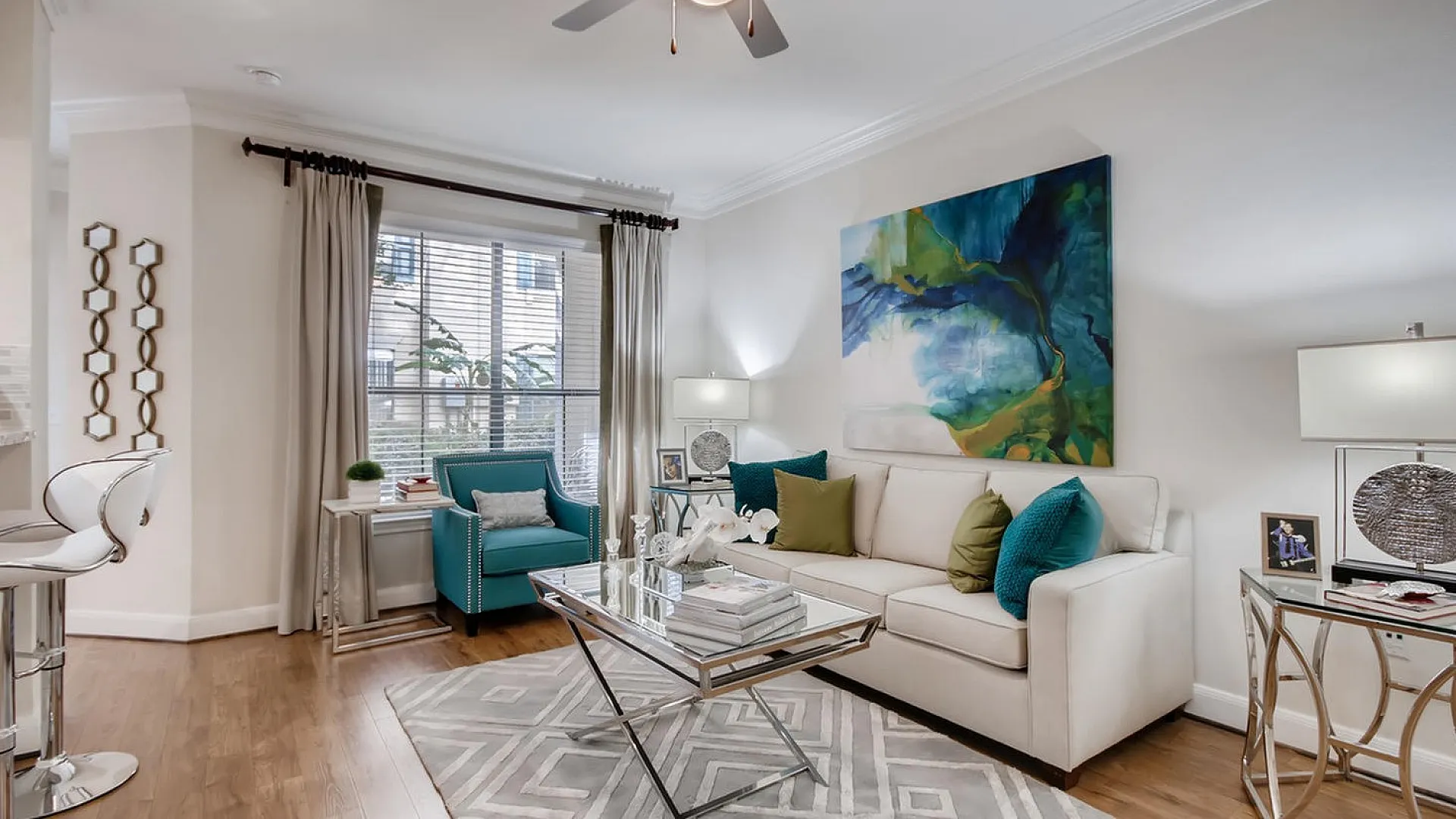 Chic living room with modern decor, featuring a cozy sofa, vibrant teal armchair, and elegant artwork enhancing the inviting atmosphere.