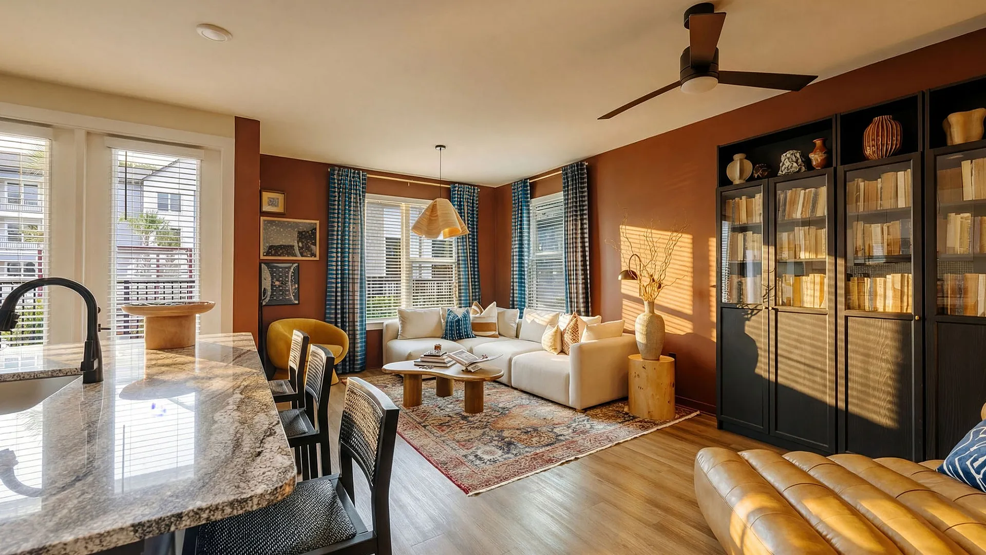 Inviting living space with natural light, featuring a plush sectional sofa, elegant decor, and a sleek kitchen bar.