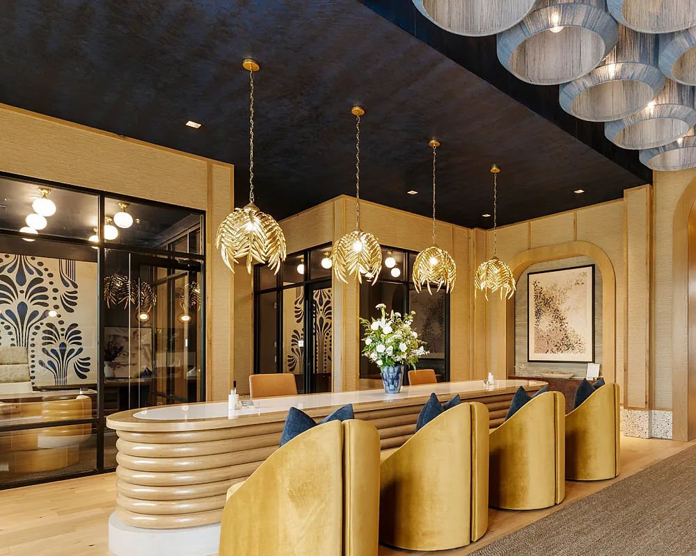 Luxurious lounge area with elegant lighting, modern decor, and plush gold seating, offering a sophisticated ambiance.