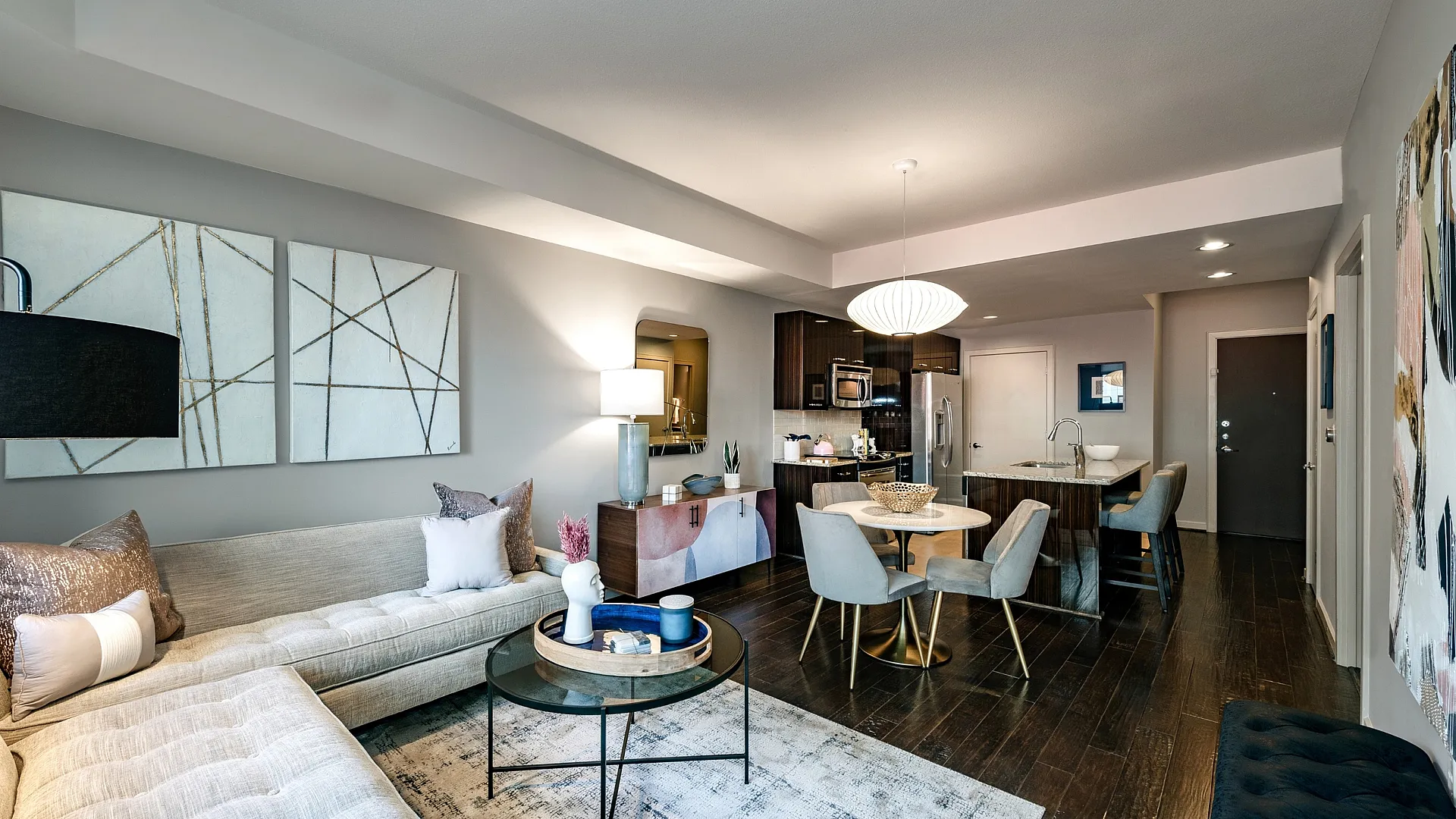 Chic modern apartment living area with open-concept kitchen, elegant dining set, and cozy corner sofa for a stylish lifestyle.