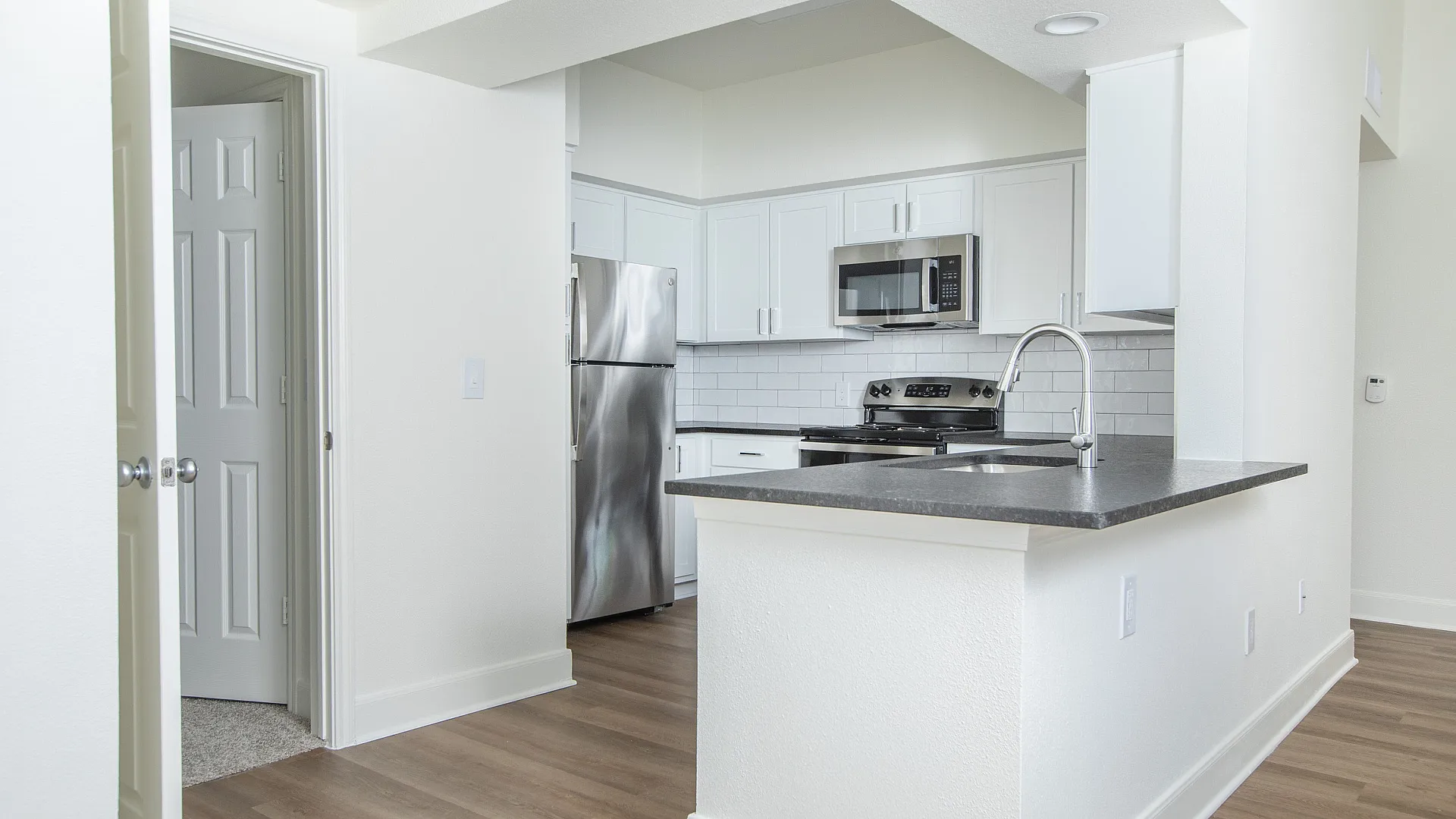 Modern kitchen with sleek stainless steel appliances, elegant white cabinetry, and chic decor, offering a spacious and inviting cooking area.