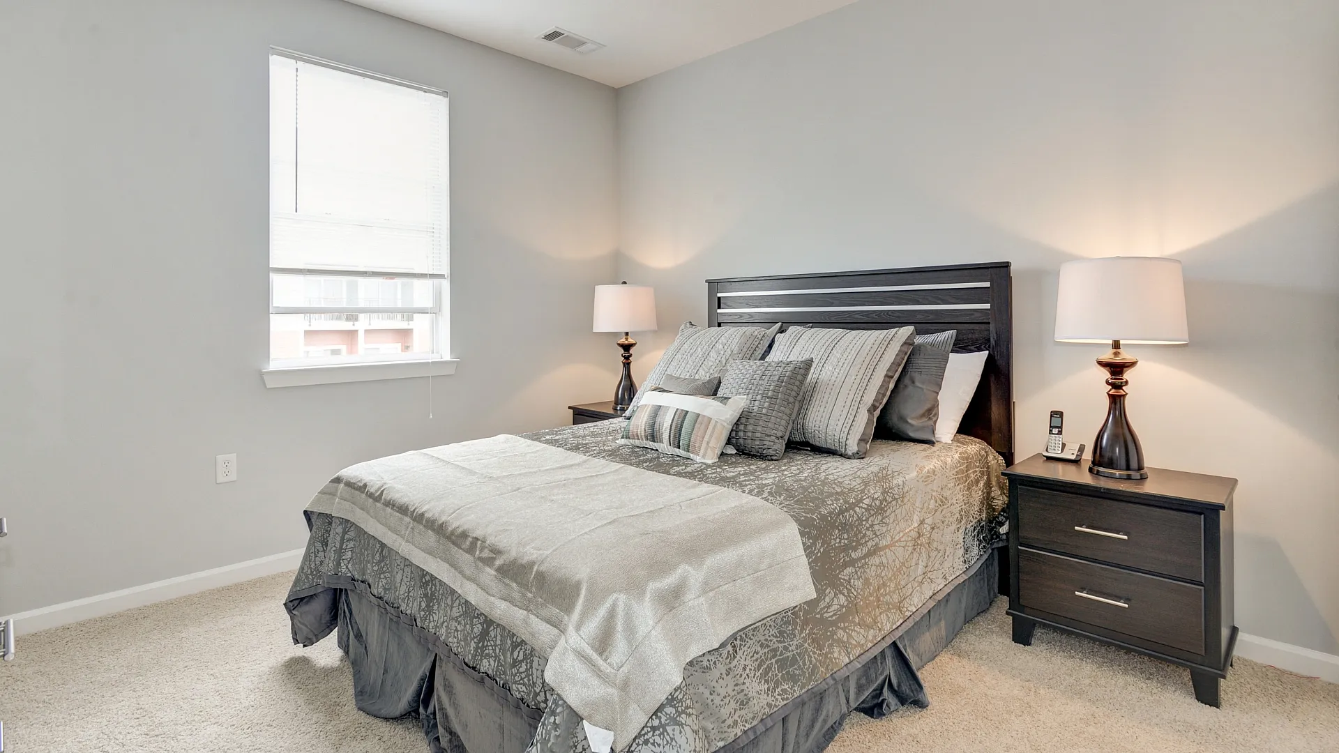 Elegant and cozy bedroom featuring a plush queen-sized bed, luxurious bedding, and ambient bedside lighting that enhances the calming atmosphere.