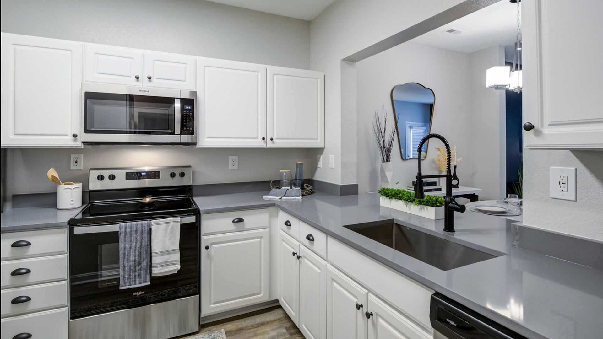 Modern kitchen with sleek gray countertops, stainless steel appliances, and white cabinetry offering a bright, inviting space.