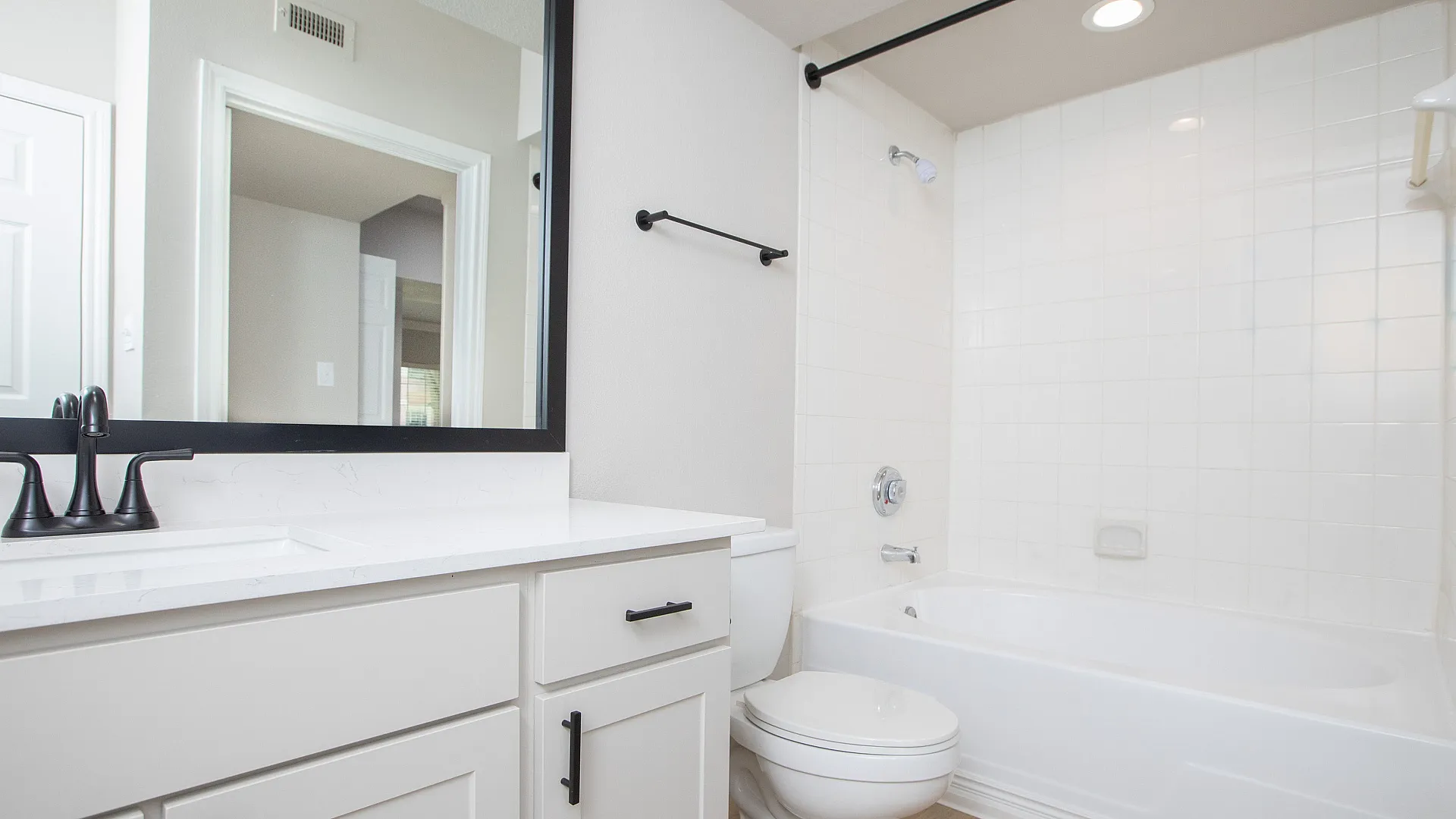 Spacious bathroom with granite countertops and tub shower combo