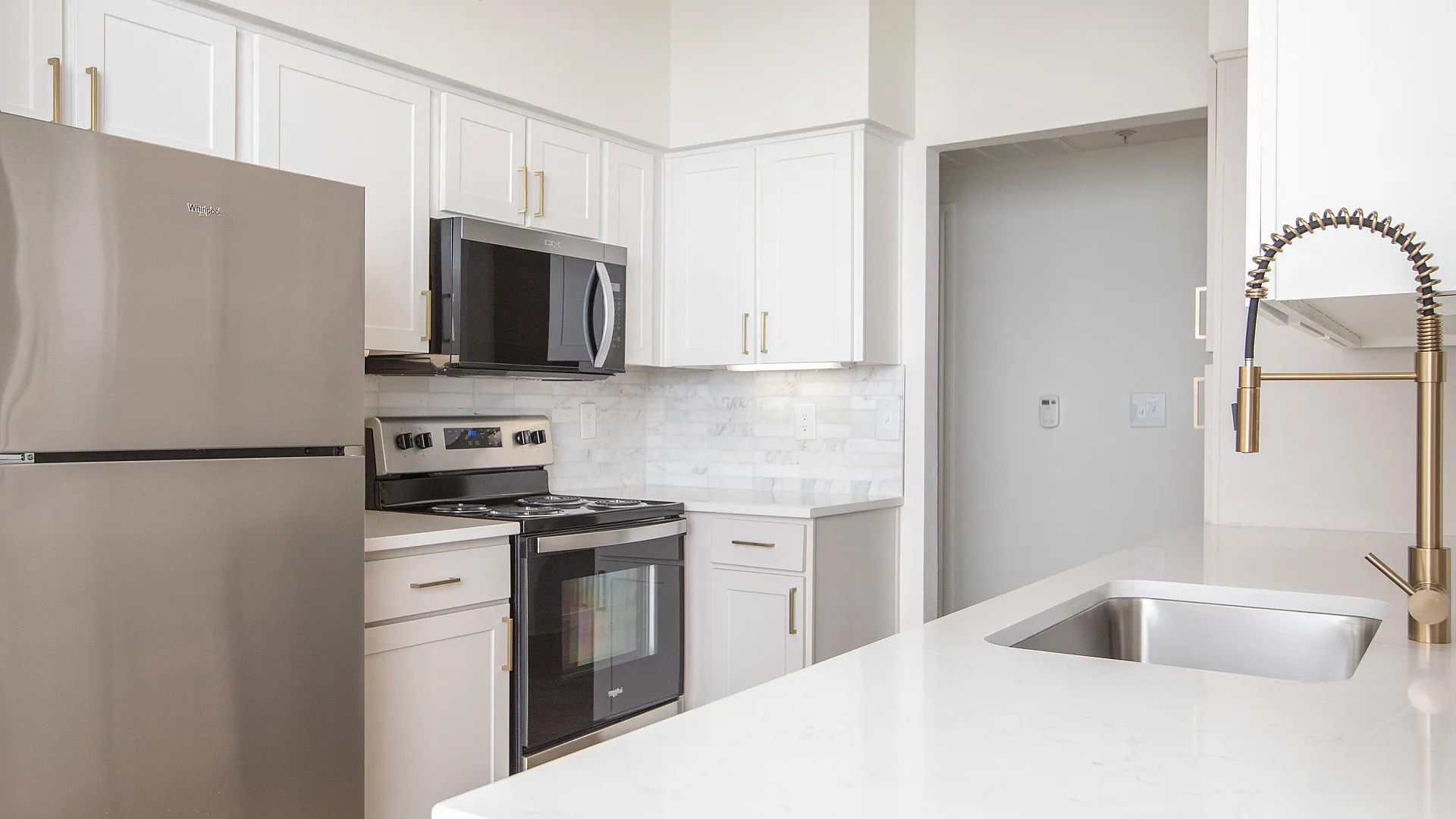Updated kitchen with gold finishes and stainless steel appliances