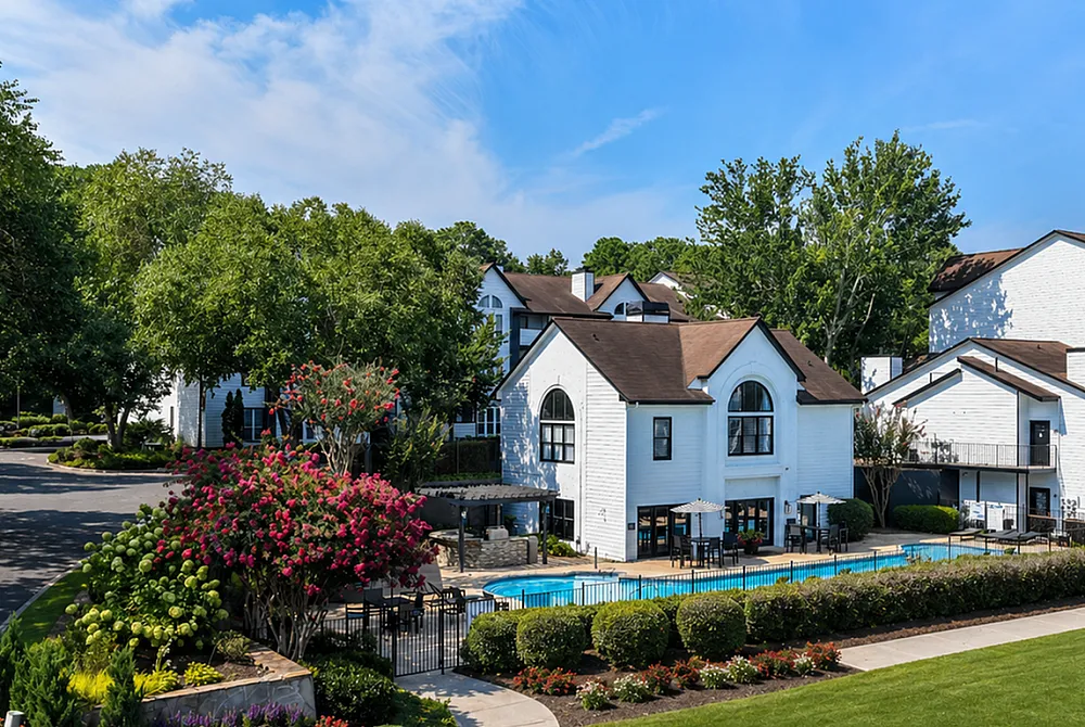 Charming apartment complex surrounded by lush greenery, featuring modern architecture and a sparkling swimming pool for relaxation.
