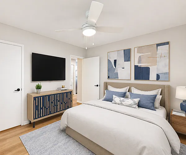 Chic bedroom with modern decor, featuring a cozy bed, stylish artwork, and a sleek TV console.