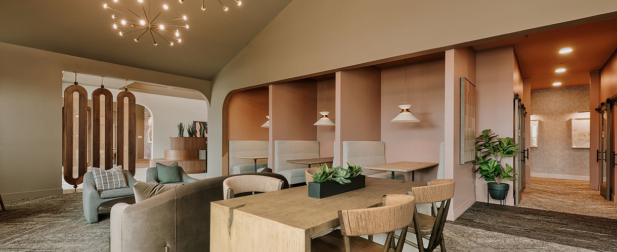 Luxurious open-concept living space with modern chandeliers, elegant seating, and stylish wooden accents.