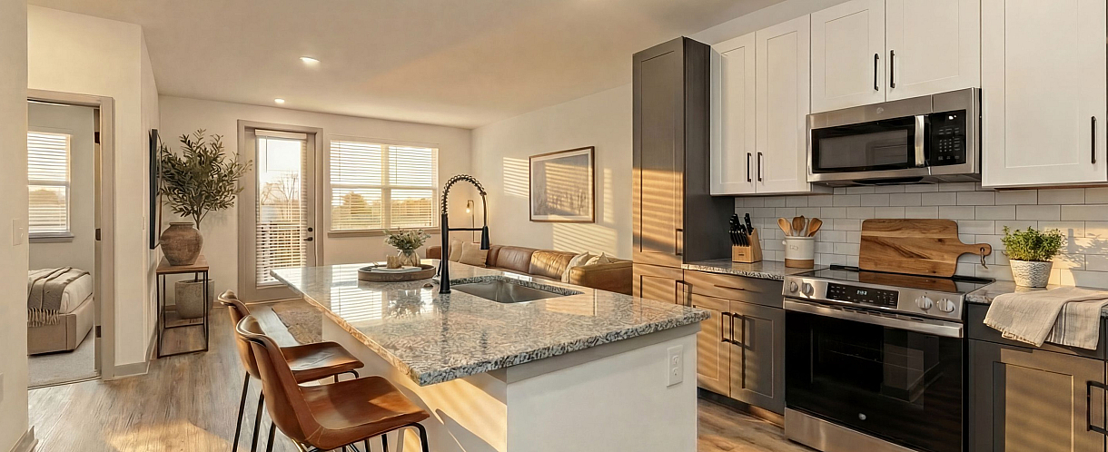 Modern open-concept kitchen with granite countertops, elegant cabinetry, and sunny living area with cozy seating.