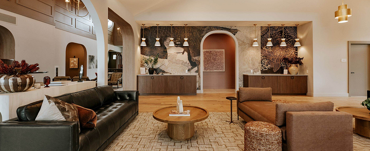 Elegant living space with modern, stylish decor, featuring plush seating, artistic wall design, and ambient lighting.